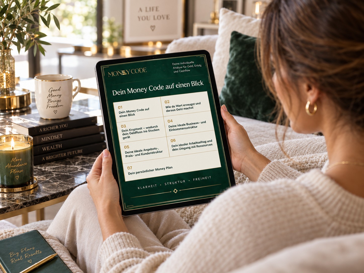 Frau sitzt auf dem Sofa und liest den Money Code auf einem Tablet